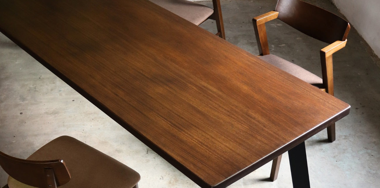 Wooden dining table with four chairs in a minimalistic setting