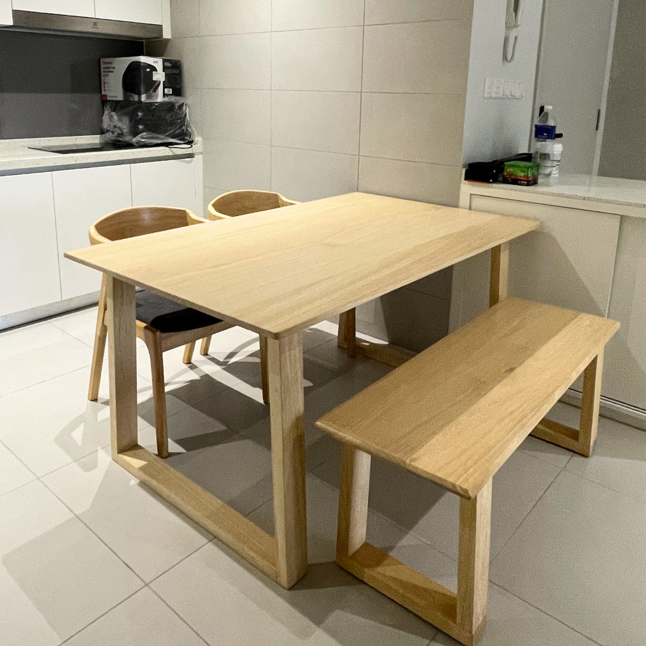 Wooden dining table with chairs and a bench in a kitchen setting