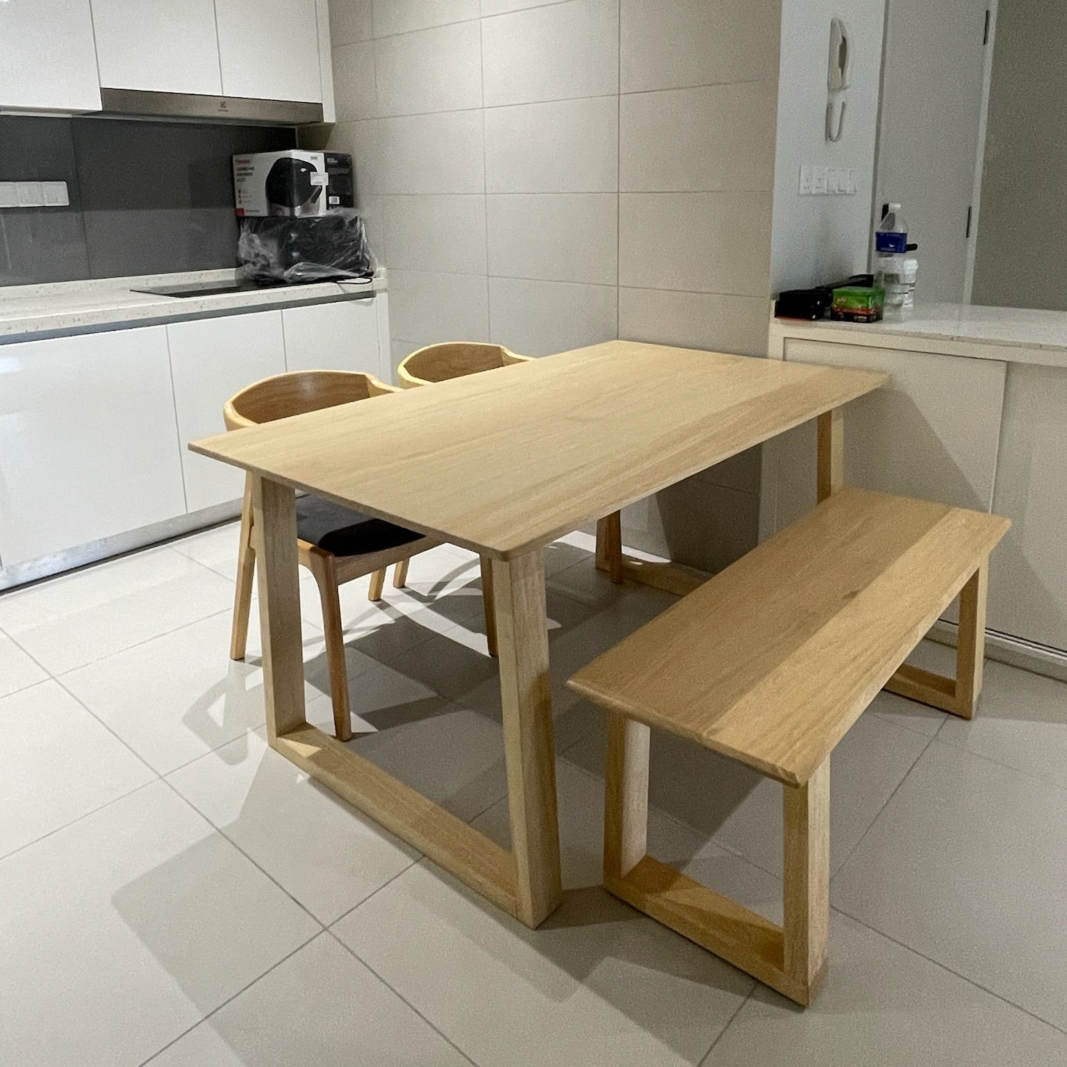 Wooden dining table with chairs and bench in a kitchen setting
