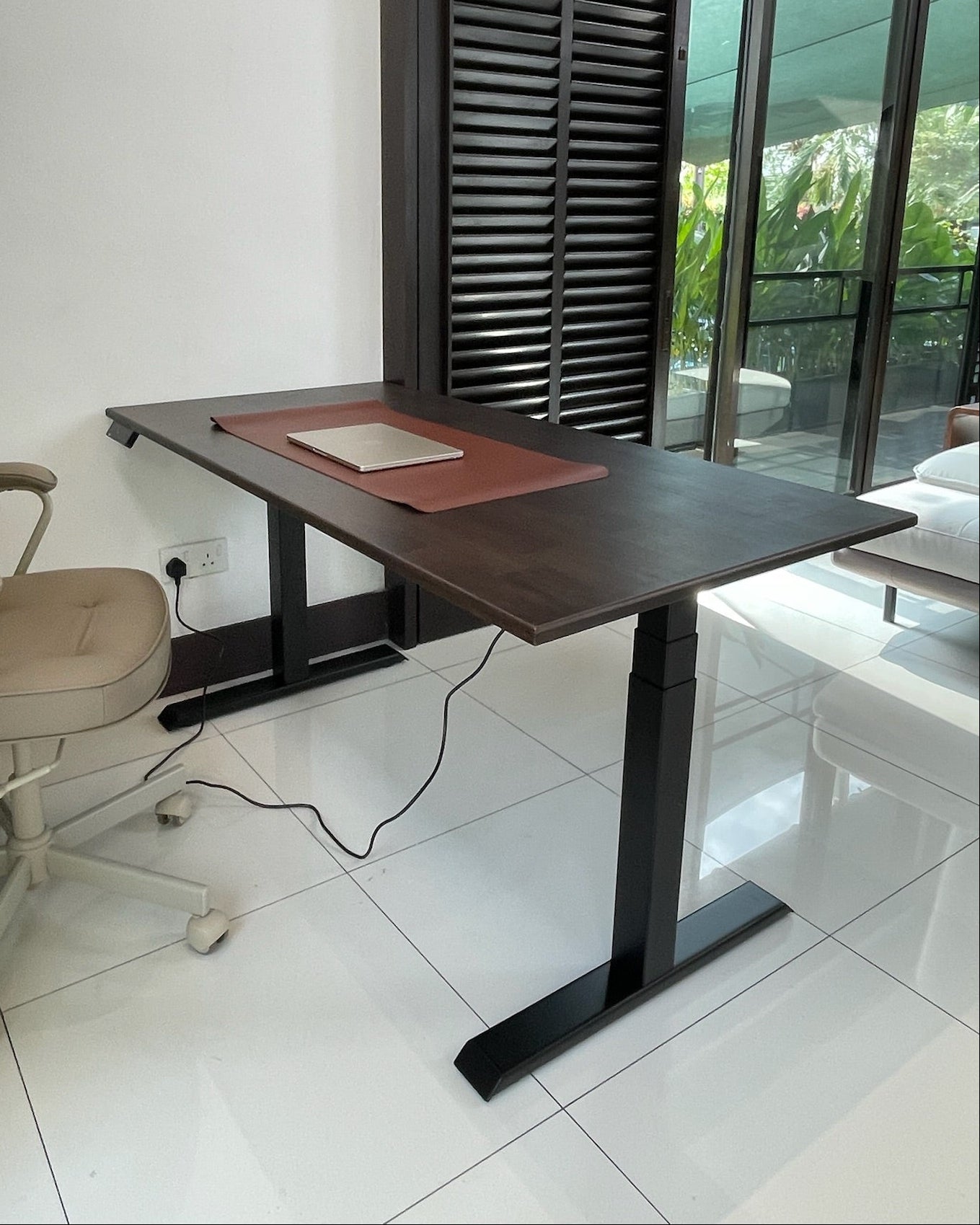 Wooden standing desk with a chair in an office setting