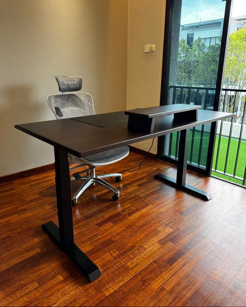 Modern office setup with a solid wood standing desk and chair in a room with large windows.