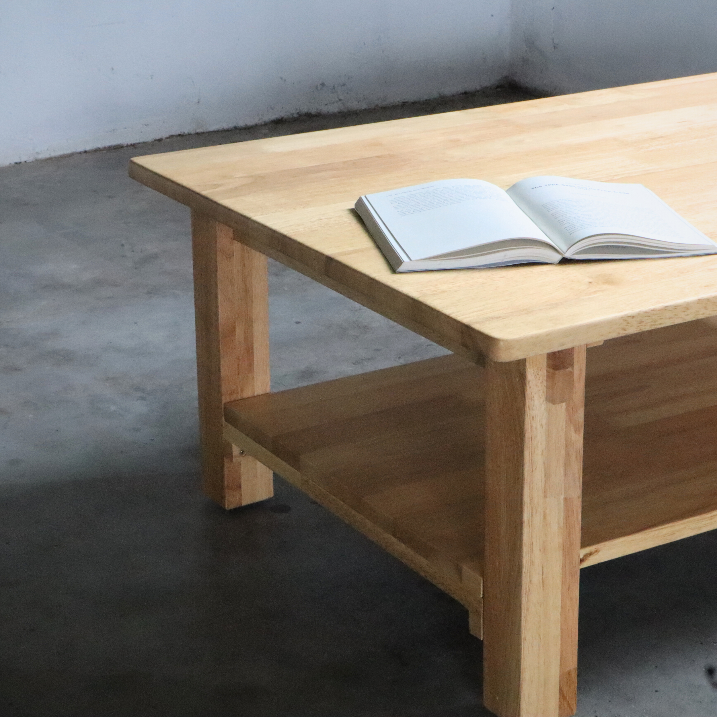 Wooden coffee table with an open book for living room.