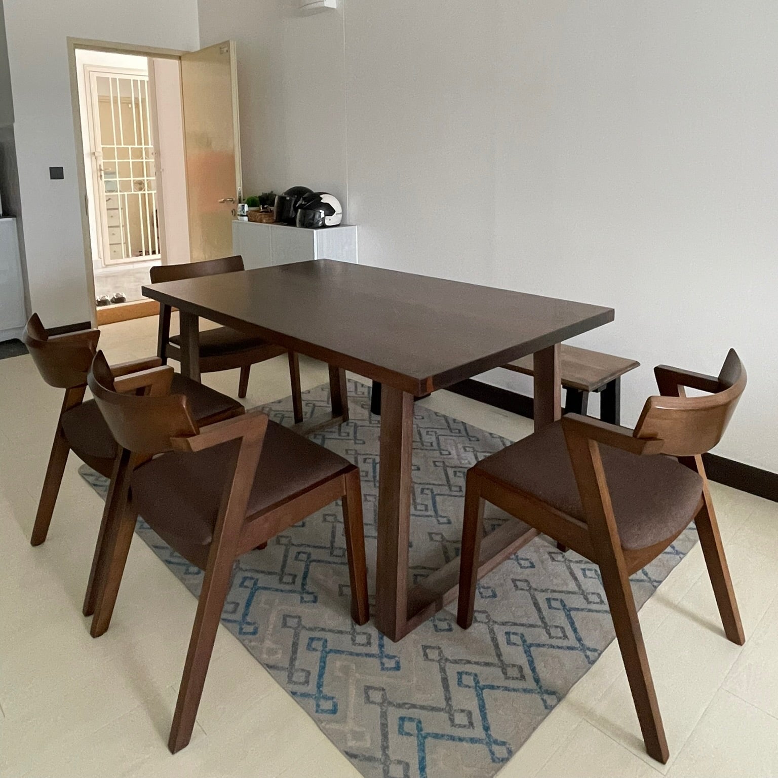 Dining area with wooden table and chairs on a patterned rug
