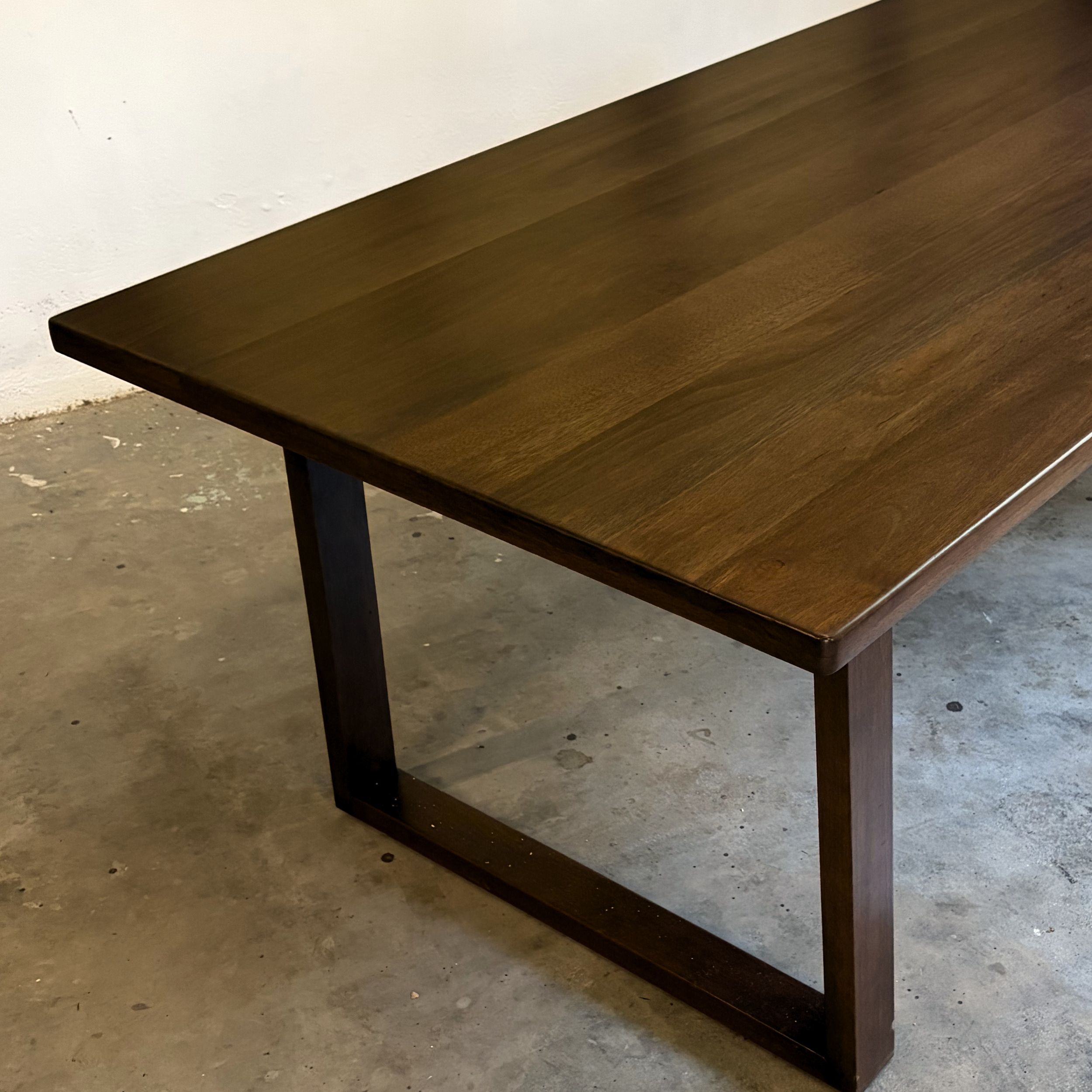 Wooden table with a dark finish on a concrete floor.