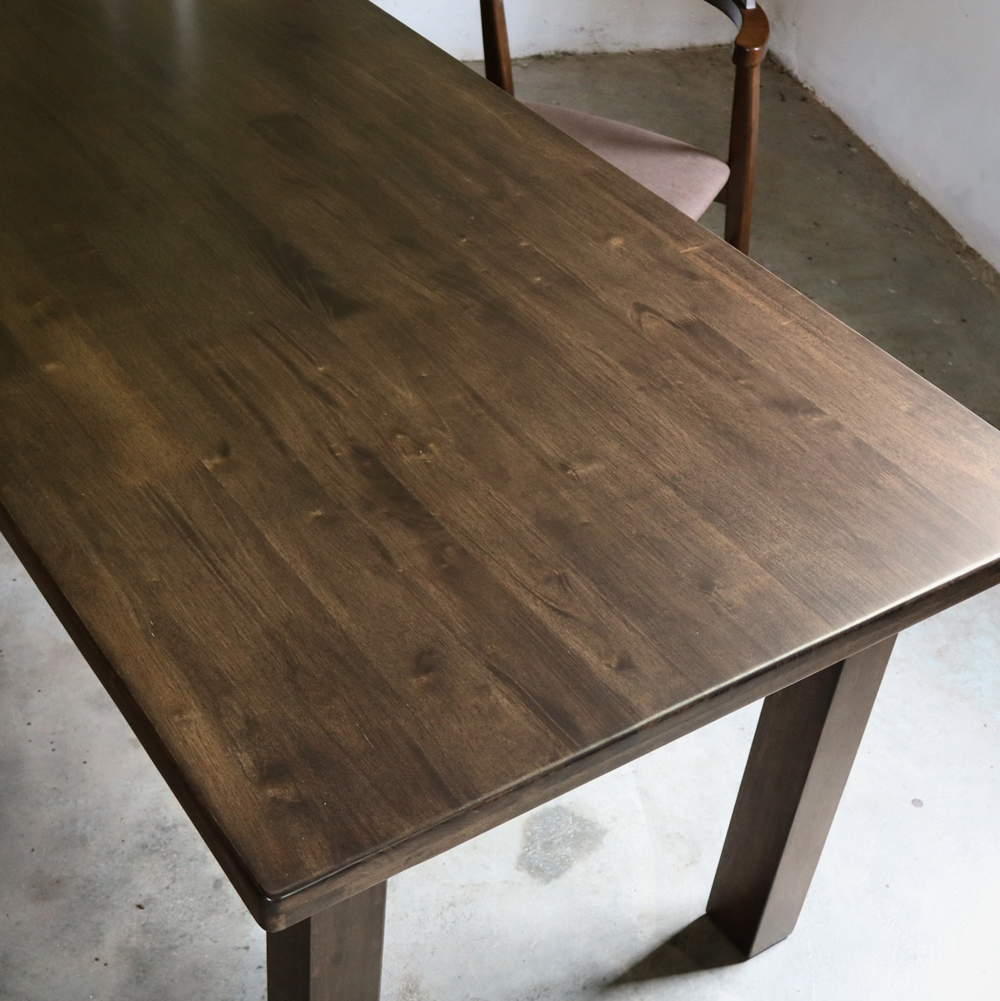 Wooden dining table with a chair in a minimalistic room.